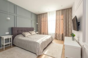 Elegant bedroom interior with modern design featuring a comfortable bed and ample natural light.